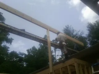 Carpenter setting a ridge beam over a new addition frame — Ice Dam Removal by Roofing Brothers in San Bruno