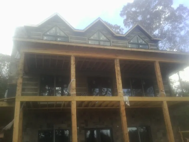 Dormers and porch framing on a large log home under construction — Roof Coating work by our crew in San Bruno